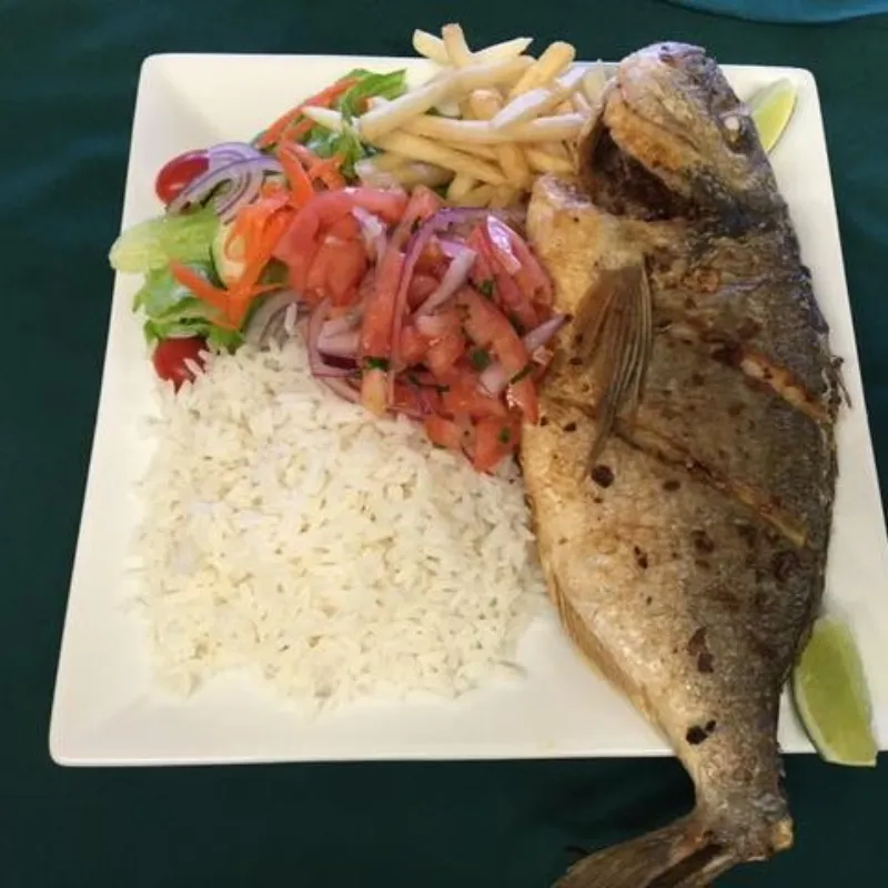 Whole grilled fish with rice, salad and fries