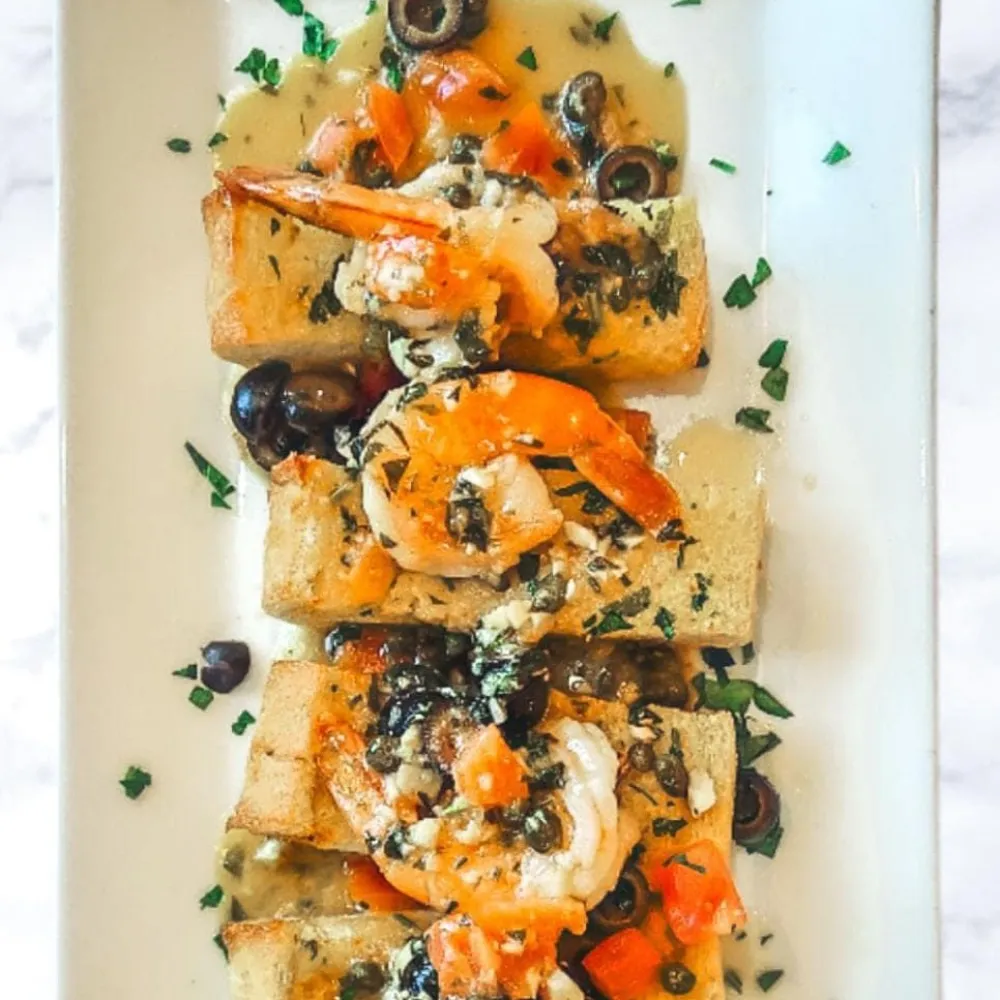 Shrimp with olives and herbs over toasted bread